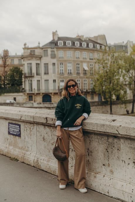 Sara from Collage Vintage at Paris Fashion Week wearing a oversize green sweatshirt, camel trousers, Louis Vuitton vintage bag and sneakers.