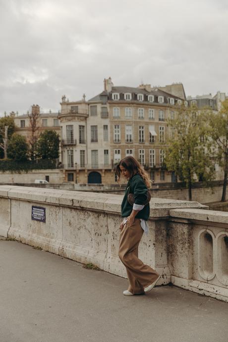 Sara from Collage Vintage at Paris Fashion Week wearing a oversize green sweatshirt, camel trousers, Louis Vuitton vintage bag and sneakers.