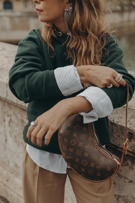 Sara from Collage Vintage at Paris Fashion Week wearing a oversize green sweatshirt, camel trousers, Louis Vuitton vintage bag and sneakers.