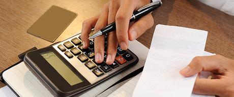 Manos de una persona, una en la calculadora y otra sosteniendo un ticket factura Manos de una persona, una en la calculadora y otra sosteniendo un ticket factura