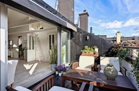 vigas blancas en el techo sofás grises muebles de terraza muebles de diseño habitación en buhardilla estilo nórdico estilo escandinavo escalera blanca curvada diseño dúplex diseño de interiores decoración en blanco decoración dúplex decoración de interiores decoración de áticos decoración áticos dúplex chimenea diseño ático ático con vistas 