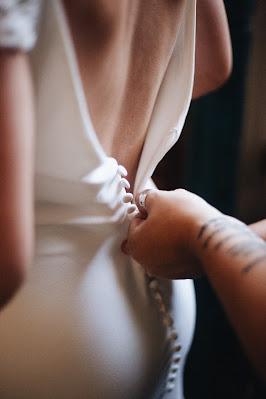 Abrochando los botones de un vestido de novia