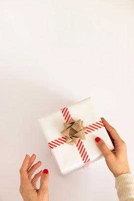 Manos femeninas entregando un regalo