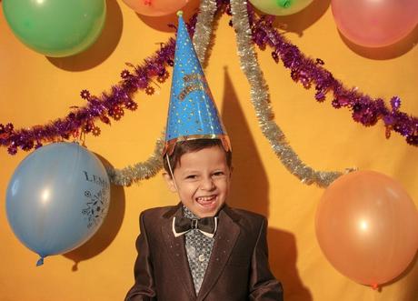 niño con gorrito y globos de cumpleaños