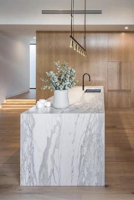 Cocina minimalista con isla de mármol veteado