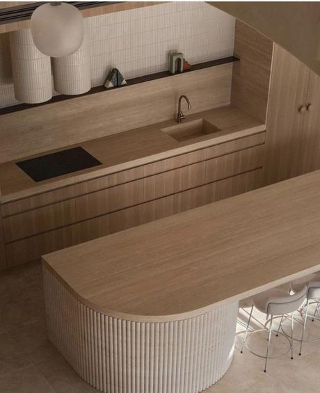 Cocina minimalista con isla de madera y formas orgánicas