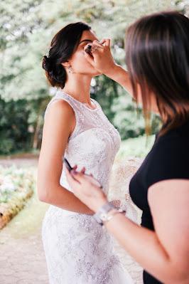 Maquilladora aplicando polvos a la novia con una brocha
