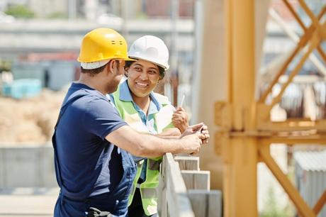 El valor de las personas en la construcción a man and woman wearing hard hat while talking