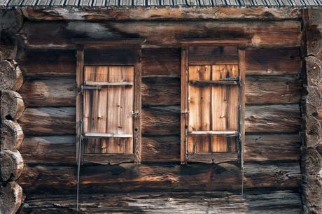 closed windows of weathered wooden hut in countryside