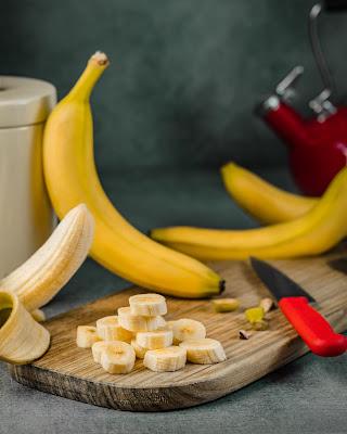 Plátanos enteros y cortados en rodajas sobre una tabla