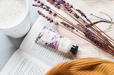 Crema de manos sobre un libro, con un café y ramas de lavanda Crema de manos sobre un libro, con un café y ramas de lavanda