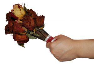 una mano entrega un ramo de flores