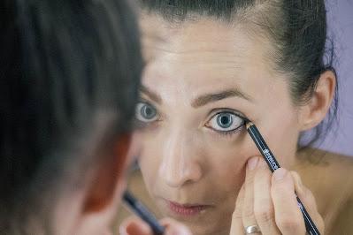 Mujer maquillándose los ojos con lápiz