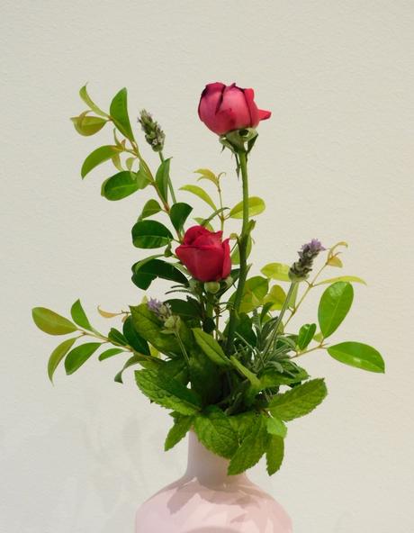 Botella, pintura de pizarra y flores escasas.