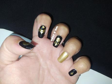 Diseño de uñas en negro y dorado con pegatinas