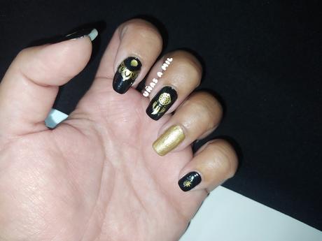 Diseño de uñas en negro y dorado con pegatinas