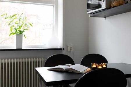 suelo de parquet espigado sofá de cuero negro silla eames blanco Poul Kjærholm PK 22 de Poul Kjaerholm para Fritz Hansen piel cordero decoración mesa de cristal y metal estilo nórdico estilo escandinavo estilo decoración masculino diseño nórdico decoración sueca decoración nórdica decoración espacios pequeños decoración en blanco negro y gris decoración con flexos 