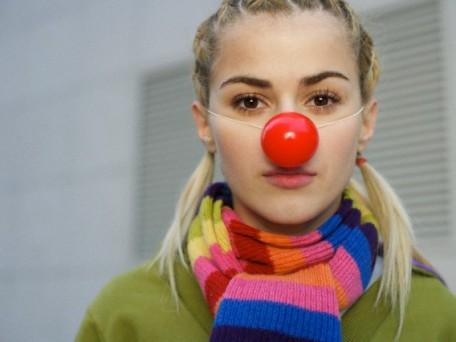 Young woman wearing red nose
