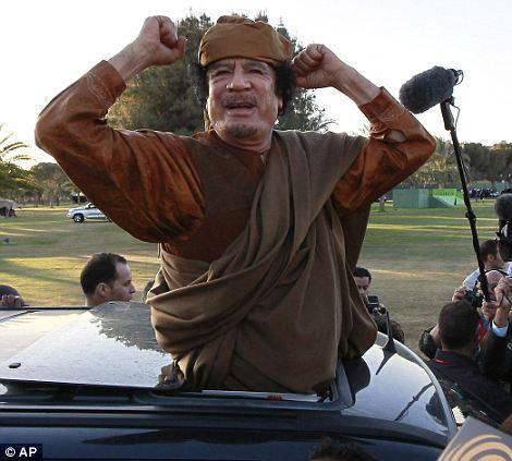 Libyan leader Colonel Gaddafi waves at his supporters people in Tripoli on April 10