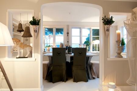 suelos de madera blanca paredes y techos panelados blancos muebles vintage muebles de formas redondeadas fundas de tela de sillas Estilo nórdico romántico estilo femenino decoración femenina decoración estilo nórdico 