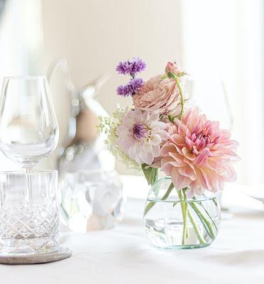 Centro de mesa sencillo con flores en tonos rosados y morados