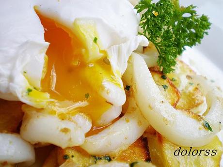 Sepia salteada sobre lecho de patatas y huevo poché