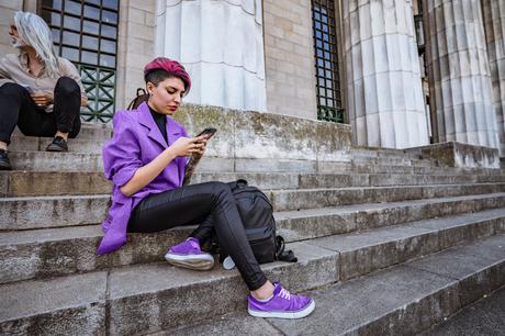 Young woman using phone on stairs