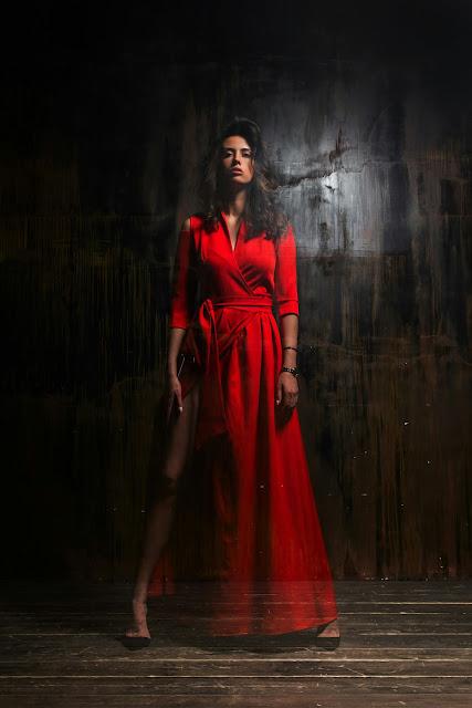 Mujer vestida con un traje largo rojo y con actitud desafiante