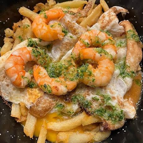 Patatas fritas con huevos rotos y langostinos al ajillo Patatas fritas con huevos rotos y langostinos al ajillo