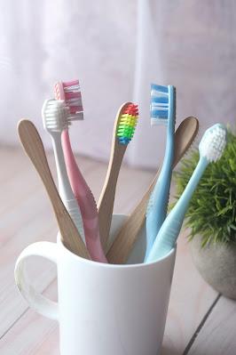 Cepillos de dientes de distintos tipo y colores en una taza