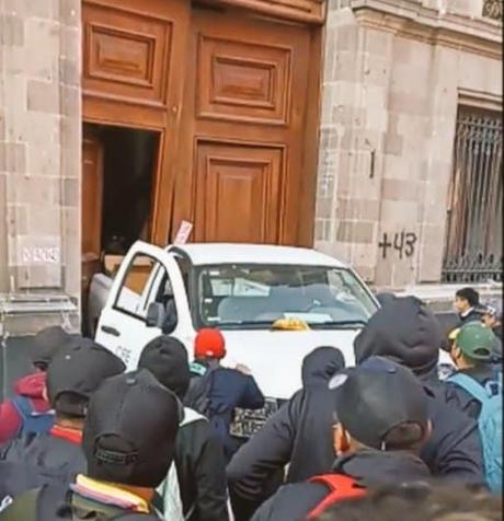 Normalistas derriban puertas del Palacio Nacional con camioneta de la CFE