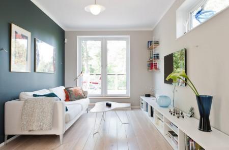 Un salón cocina comedor en dos niveles taburete tolix naranja sofas blancos muebles de ikea estilo sueco decoración estilo nórdico diseño de interiores decoración en blanco decoración de interiores diáfanos cocinas modernas cocinas blancas cocinas abiertas casa sueca en el campo