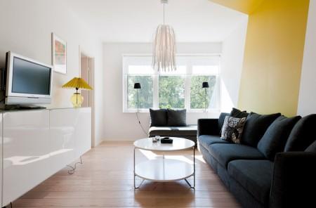 Un salón cocina comedor en dos niveles taburete tolix naranja sofas blancos muebles de ikea estilo sueco decoración estilo nórdico diseño de interiores decoración en blanco decoración de interiores diáfanos cocinas modernas cocinas blancas cocinas abiertas casa sueca en el campo