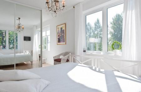 Un salón cocina comedor en dos niveles taburete tolix naranja sofas blancos muebles de ikea estilo sueco decoración estilo nórdico diseño de interiores decoración en blanco decoración de interiores diáfanos cocinas modernas cocinas blancas cocinas abiertas casa sueca en el campo