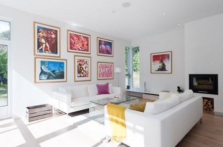 Un salón cocina comedor en dos niveles taburete tolix naranja sofas blancos muebles de ikea estilo sueco decoración estilo nórdico diseño de interiores decoración en blanco decoración de interiores diáfanos cocinas modernas cocinas blancas cocinas abiertas casa sueca en el campo