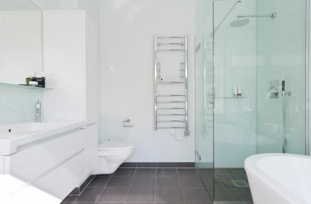 Un salón cocina comedor en dos niveles taburete tolix naranja sofas blancos muebles de ikea estilo sueco decoración estilo nórdico diseño de interiores decoración en blanco decoración de interiores diáfanos cocinas modernas cocinas blancas cocinas abiertas casa sueca en el campo