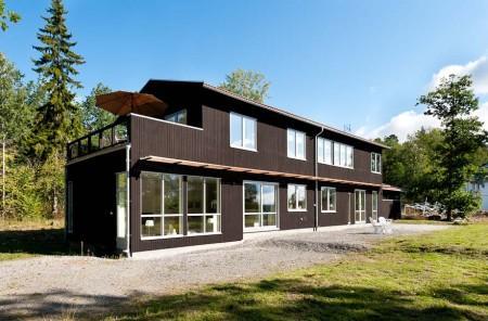 Un salón cocina comedor en dos niveles taburete tolix naranja sofas blancos muebles de ikea estilo sueco decoración estilo nórdico diseño de interiores decoración en blanco decoración de interiores diáfanos cocinas modernas cocinas blancas cocinas abiertas casa sueca en el campo