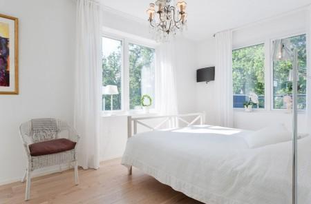 Un salón cocina comedor en dos niveles taburete tolix naranja sofas blancos muebles de ikea estilo sueco decoración estilo nórdico diseño de interiores decoración en blanco decoración de interiores diáfanos cocinas modernas cocinas blancas cocinas abiertas casa sueca en el campo