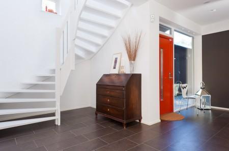 Un salón cocina comedor en dos niveles taburete tolix naranja sofas blancos muebles de ikea estilo sueco decoración estilo nórdico diseño de interiores decoración en blanco decoración de interiores diáfanos cocinas modernas cocinas blancas cocinas abiertas casa sueca en el campo