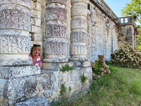 Jennifer posa entre las columnas de piedra tallada de la fachada del castillo de Vayres