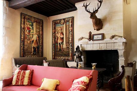 Cuelga tapices y una cabeza de ciervo está montada en la pared sobre la chimenea del salón del Château de Vayres.