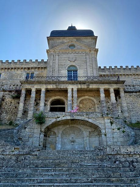 Jennifer sentada en la cornisa en lo alto de la monumental escalera del Château de Vayres