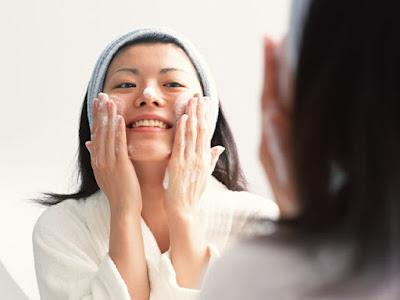 Mujer limpiándose el rostro con espuma