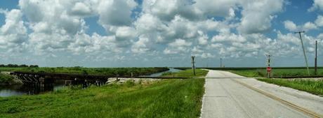 Miami Canal y la calle en el tramo asfaltado y un cruce ferroviario