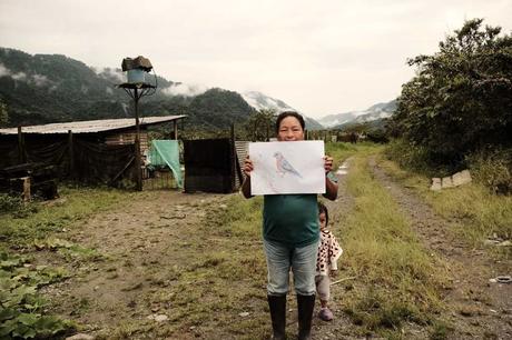 Jacinta Rosa Avilés de 54 años junto a su nieta Dara de dos años de edad muestra un dibujo de fauna local como parte de las tareas escolares que realizan sus nietos. El Chaco, provincia de Napo, 2024