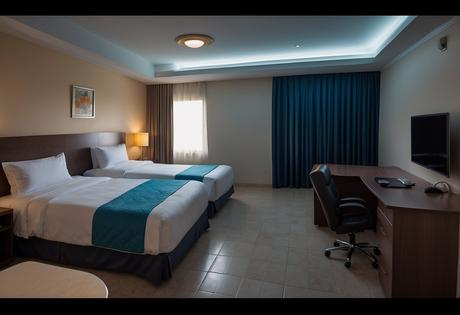 The motel room in Coatzacoalcos features a king-sized bed, a small dining table, a mini-fridge, and a spacious bathroom with a shower