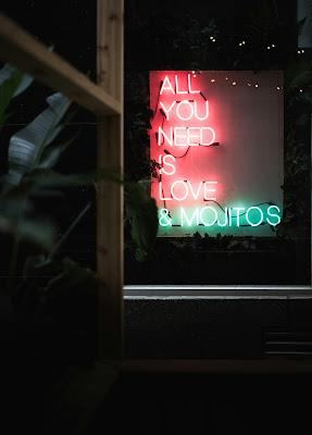 Cartel de neón en el que se lee en inglés: Todo lo que necesitas es amor y mojitos
