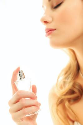 Mujer perfumándose con un vaporizador Mujer perfumándose con un vaporizador