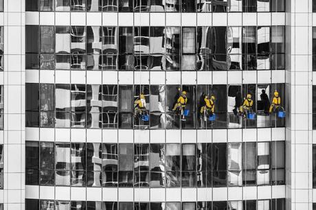 five person cleaning glass building