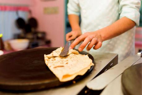 Un chef usa una espátula para darle la vuelta a una crepe